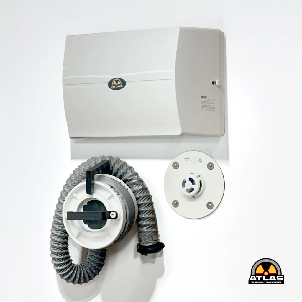 Wall-mounted Atlas survival shelter unit with a coiled hose and circular mounting hardware; Atlas logo visible on the device.