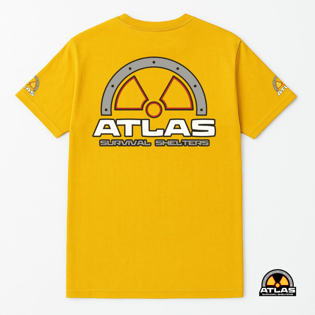 Yellow t-shirt shown from the back with a large gray circular logo containing a red-and-yellow radiation symbol; Atlas Survival Shelters branding is visible at the bottom right corner edge on a patch.