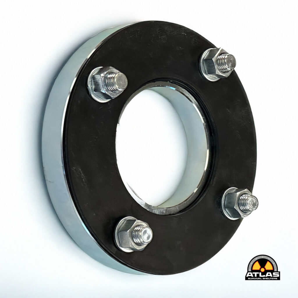 Close-up of a black circular metal flange with six bolts around the edge and an Atlas Survival Shelters logo in the bottom right.