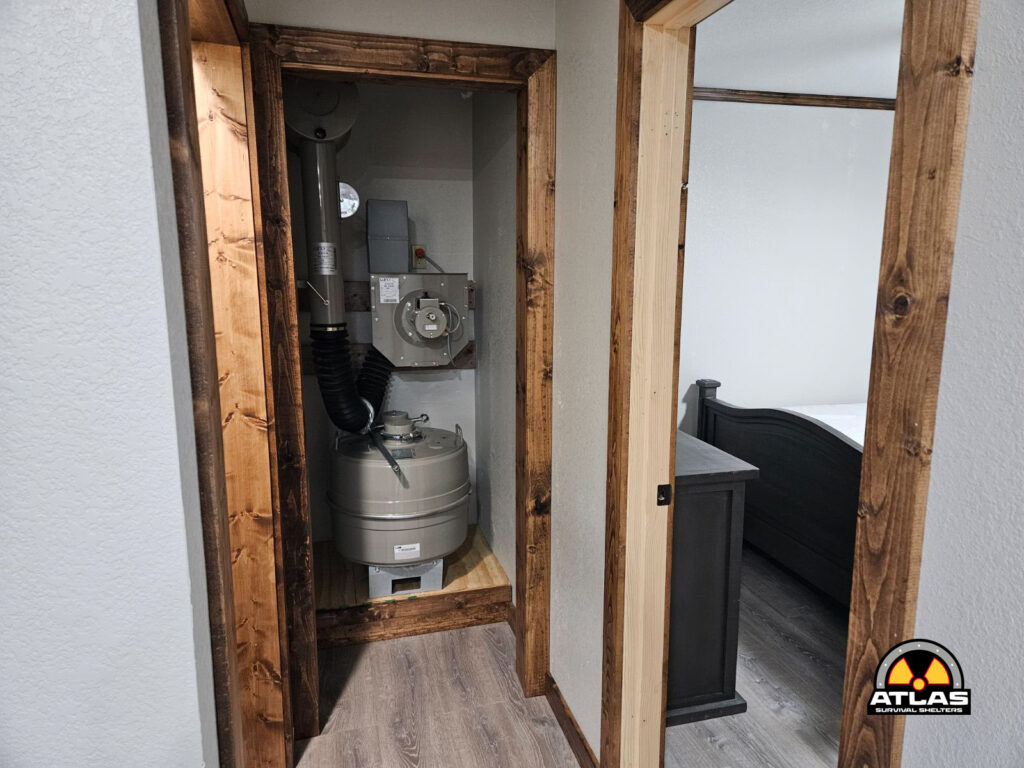 Utility closet with HVAC/propane tank equipment mounted on the wall, exposed wood framing, and a doorway to a bedroom visible to the right.