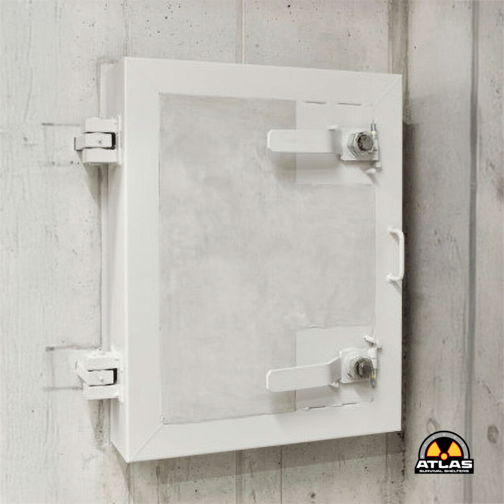 White metal door with visible hinges and latch mounted on a weathered wooden wall; Atlas Survival Shelters logo appears in the lower-right corner.