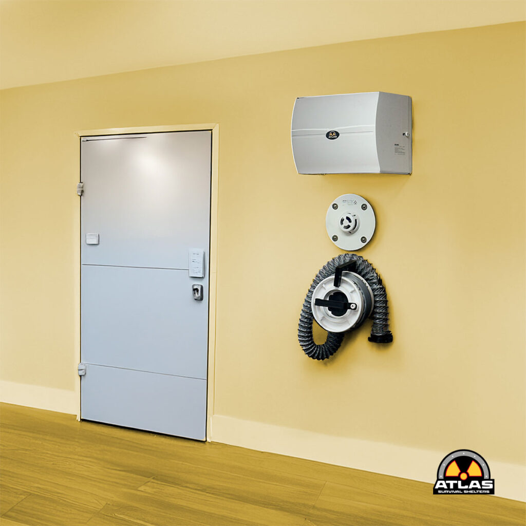 Yellow-walled interior with a gray metal door, a wall-mounted hose reel, and a circular control unit.