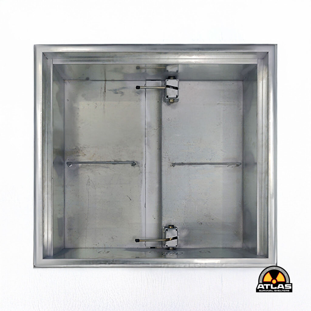 Metal industrial cabinet or safe with a metal door, internal latch system visible, logo for Atlas Survival Shelters in bottom-right corner.